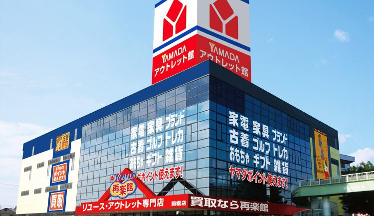 Yamada Denki store facade with logo against the backdrop of a modern cityscape