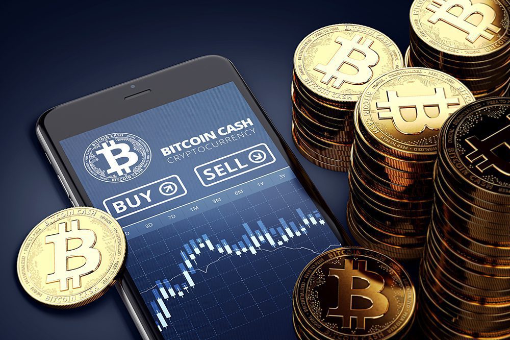 bitcoin cash app on phone near a stack of real bitcoins