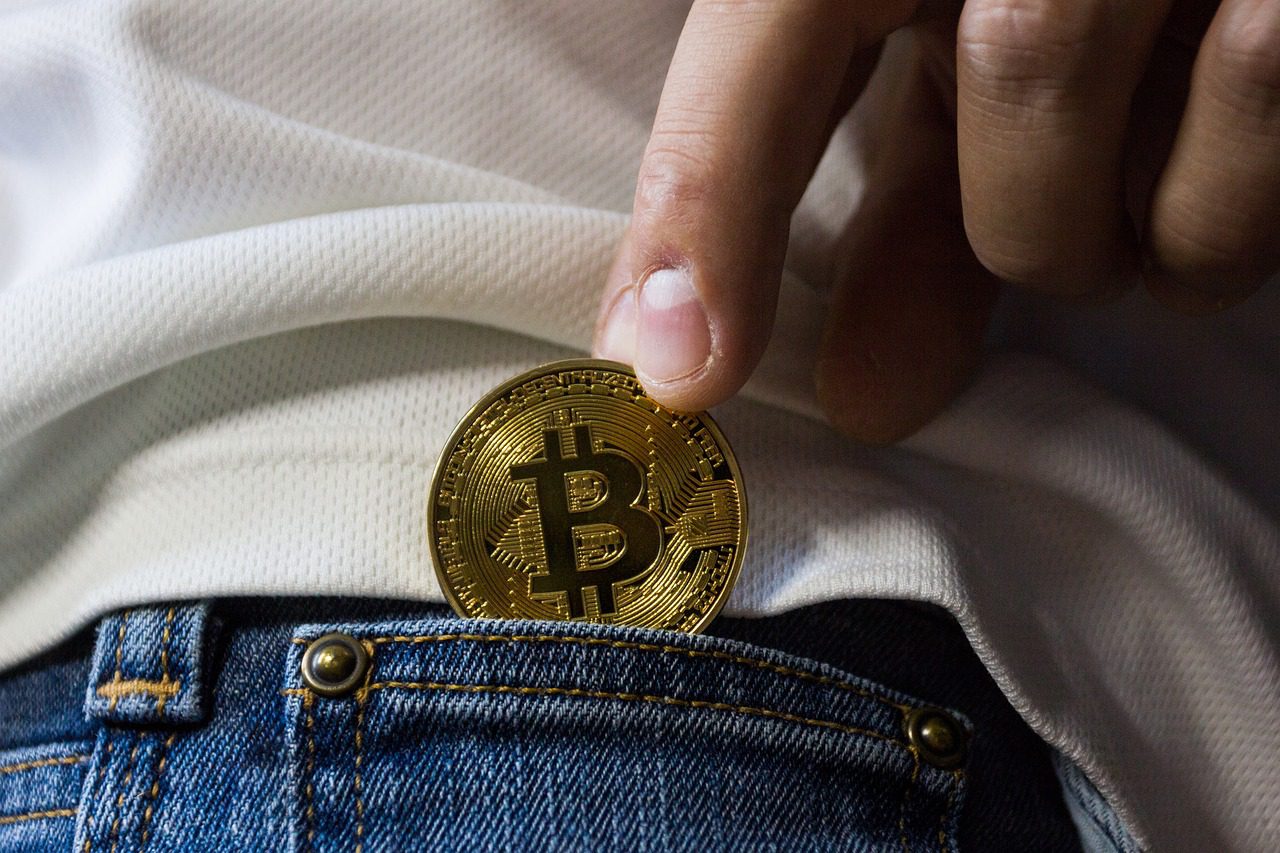hand puts bitcoin in back pocket