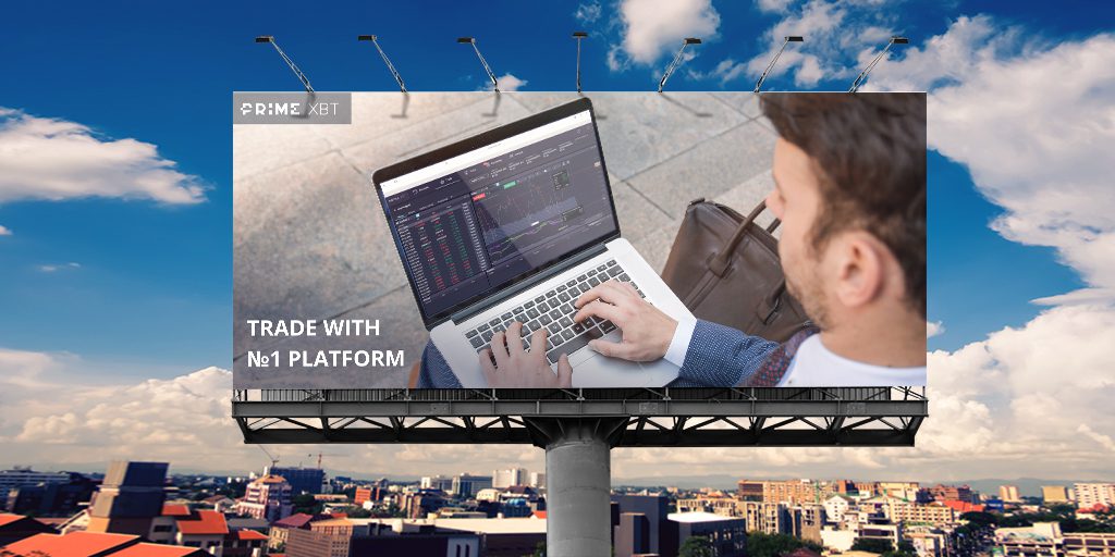 billboard showing guy sitting on the pavement and trading on a laptop
