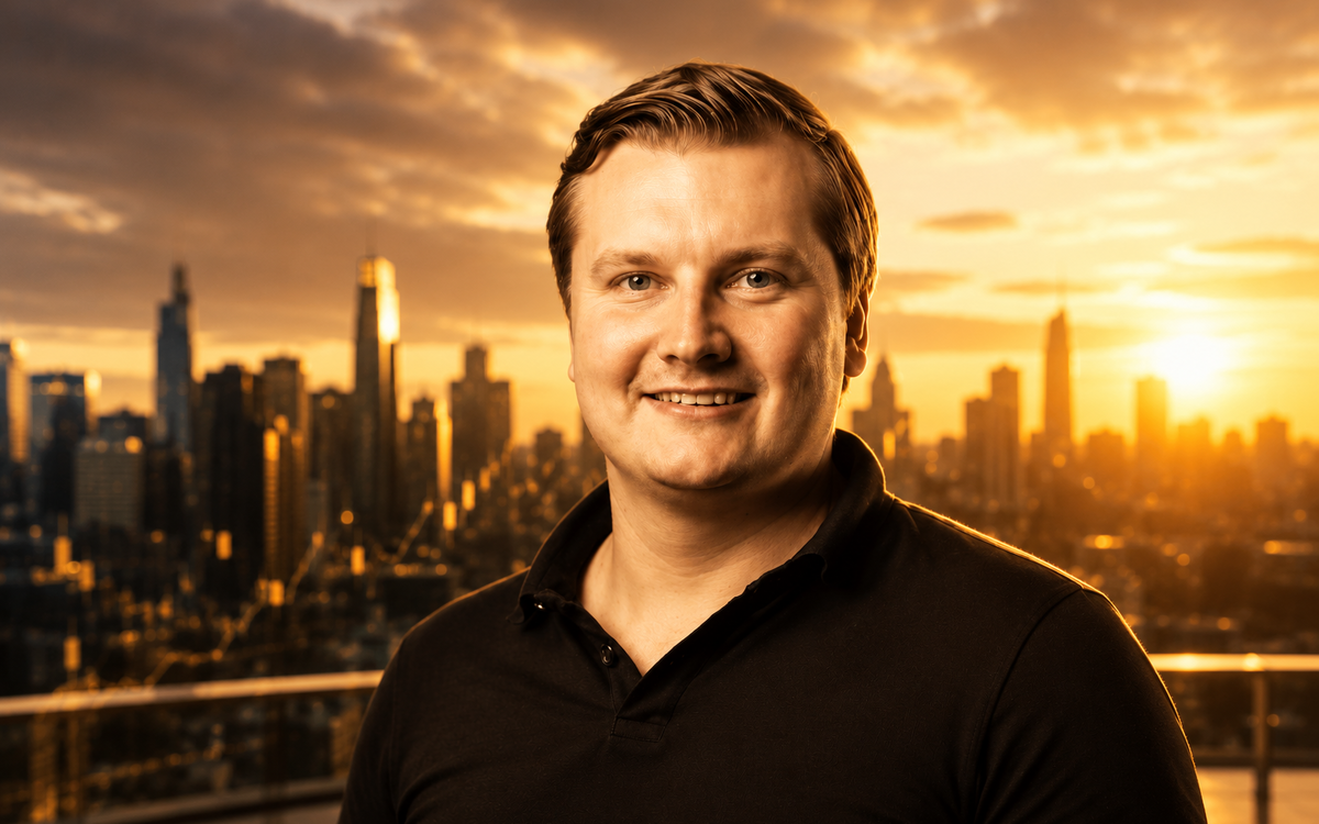 Portrait of Stani Kulechov with a golden-hour city skyline in the background.